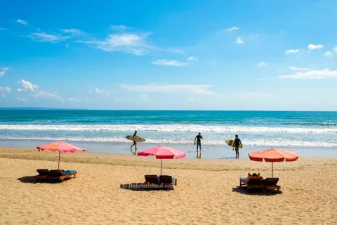 Scenic view of the blue Indian Ocean waves crashing onto the shore at Kuta Beach.