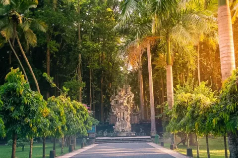 Iconic giant stone monkey statue surrounded by long-tailed macaques at Sangeh Monkey Forest.