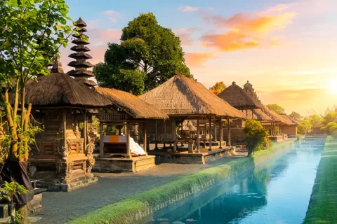Morning sunlight reflecting the iconic Meru shrine towers on the calm surface of the Taman Ayun Temple fish pond.