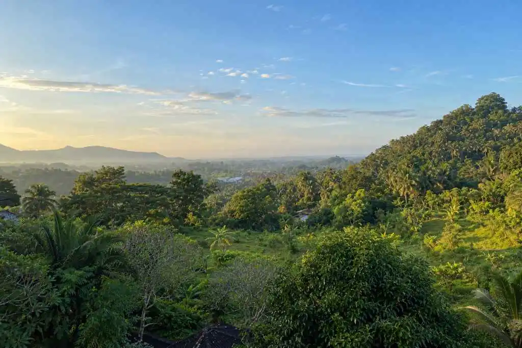 Panoramic view of Bukit Jambul’s lush green valley, tropical forest, and distant hills in Bali.