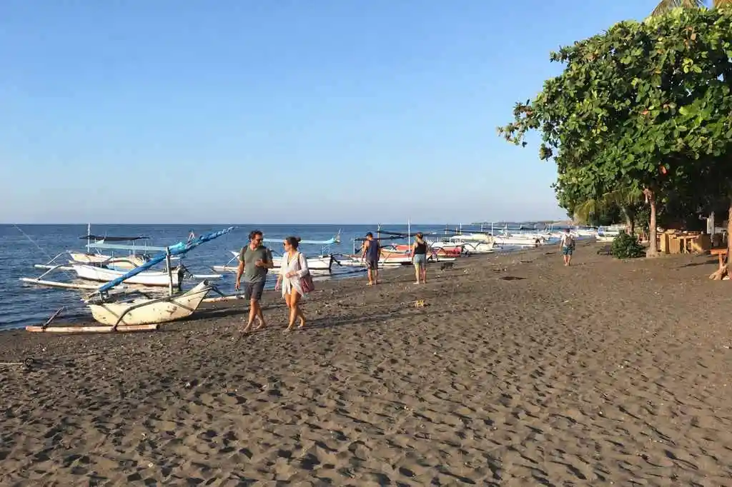 Tourists walking along Lovina Beach during a North Bali Day Tour