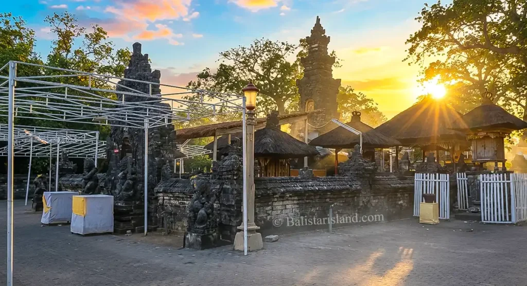 Beautiful ritual structures of Sakenan Temple glowing under a clear sunrise sky.