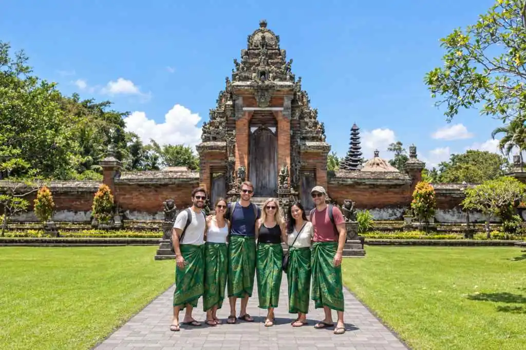 Travellers in green sarongs visiting Taman Ayun Temple on a Tanah Lot Sunset Tour