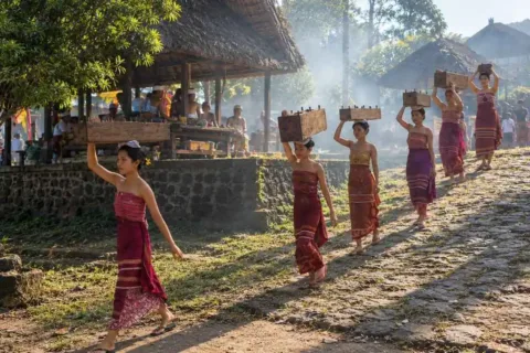 Women carrying traditional offerings through Tenganan Village in Bali