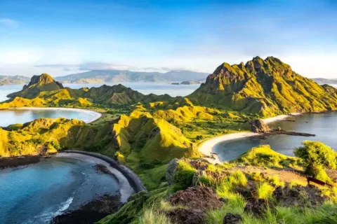 Panoramic view of the green hills, rugged islands, and crescent-shaped beaches of Komodo National Park.
