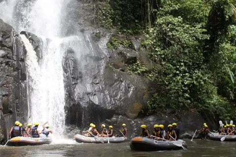 Tourists enjoying a waterfall during Mason Adventures Rafting on the Ayung River