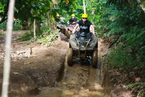 ATV rider navigating a muddy jungle trail on Pertiwi Quad Bike Adventure in Bali