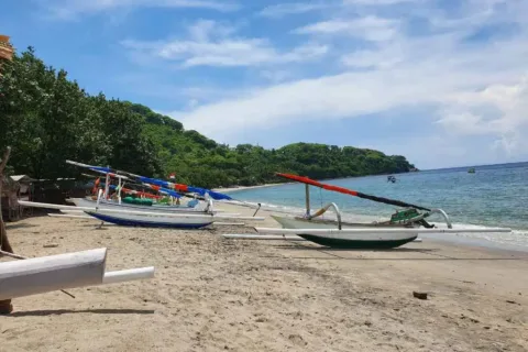 Traditional outrigger boats resting on a sandy beach in Bali and Lombok