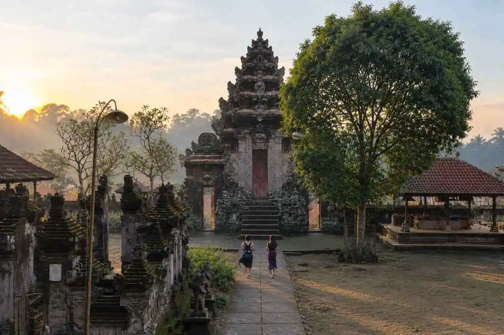 Visitors exploring Kehen Temple during the golden morning light in Bali
