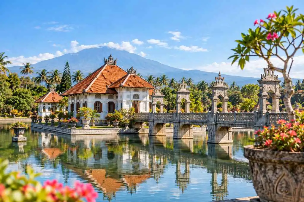 Taman Ujung Water Palace in East Bali featuring elegant Balinese architecture, a stone bridge, reflective ponds, and a mountain backdrop.